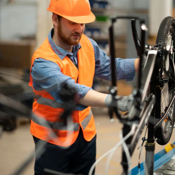 Réparation au chantier : service industriel rapide et certifié 1 Un homme avec un gilet orange, debout sur un chantier, entouré d'outils et de matériel.