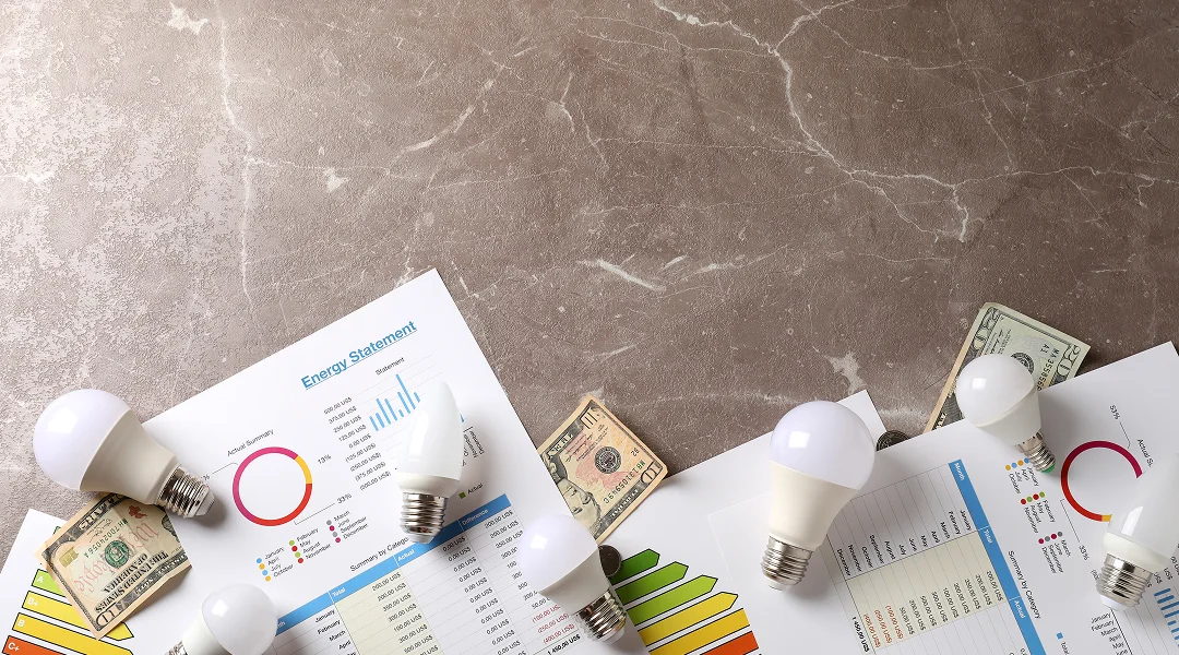 Blogue 4 Une pile de papiers avec une ampoule, un billet de dollar et une ampoule.