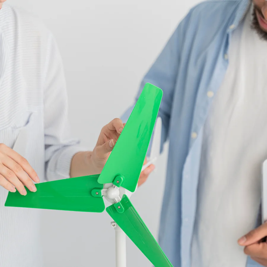 Augmentez la valeur de vos projets grâce à une efficacité énergétique intelligente : la vision du Groupe AVA 1 Un homme et une femme observent une éolienne, symbolisant l'importance de l'efficacité énergétique.