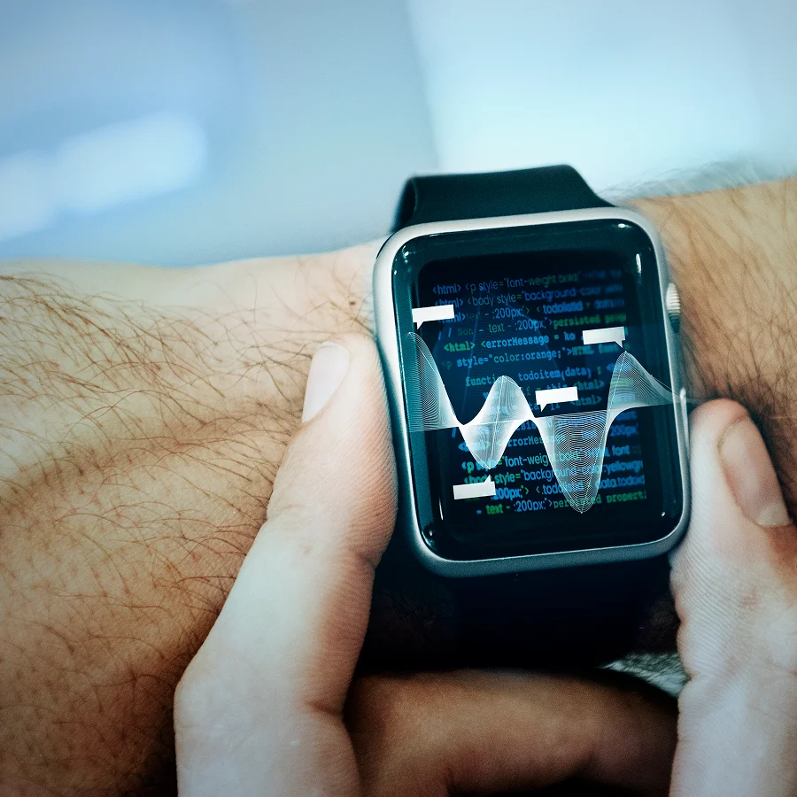 Une personne tenant une montre Apple affichant un graphique lié à la maintenance intelligente.