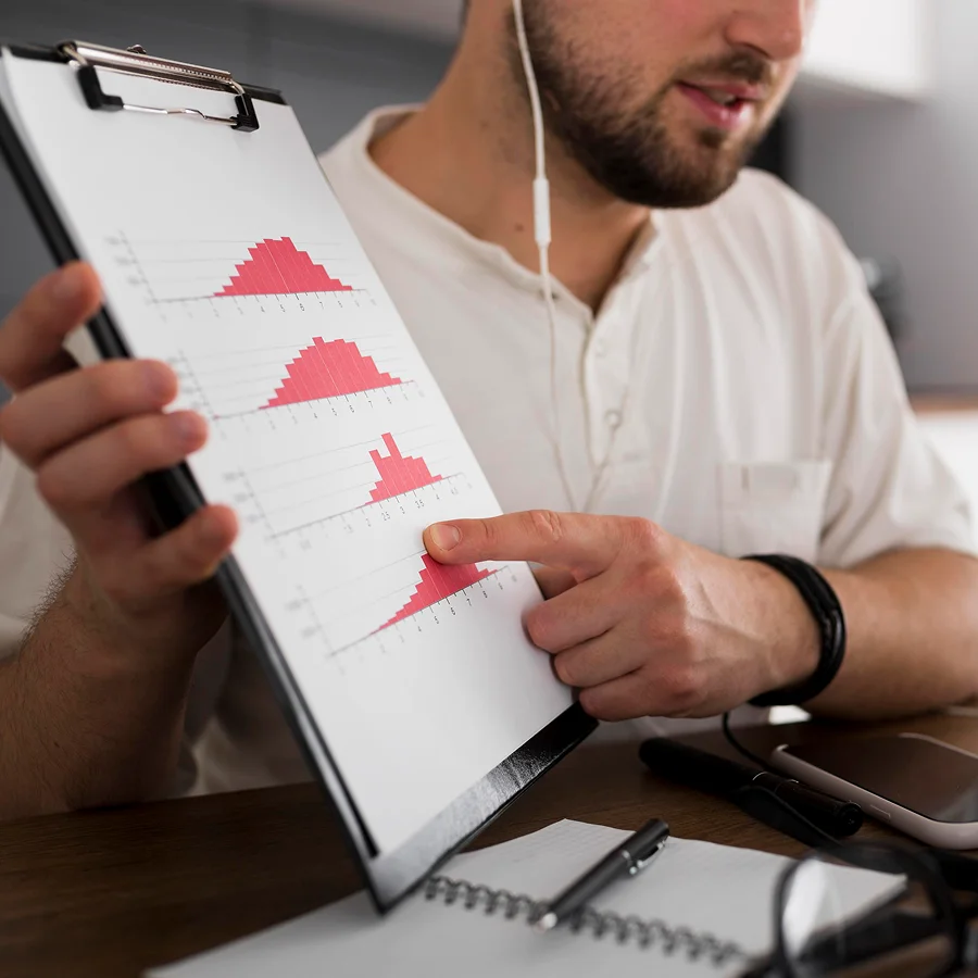 Un homme examine des graphiques sur un clipboard, illustrant une production optimisée.